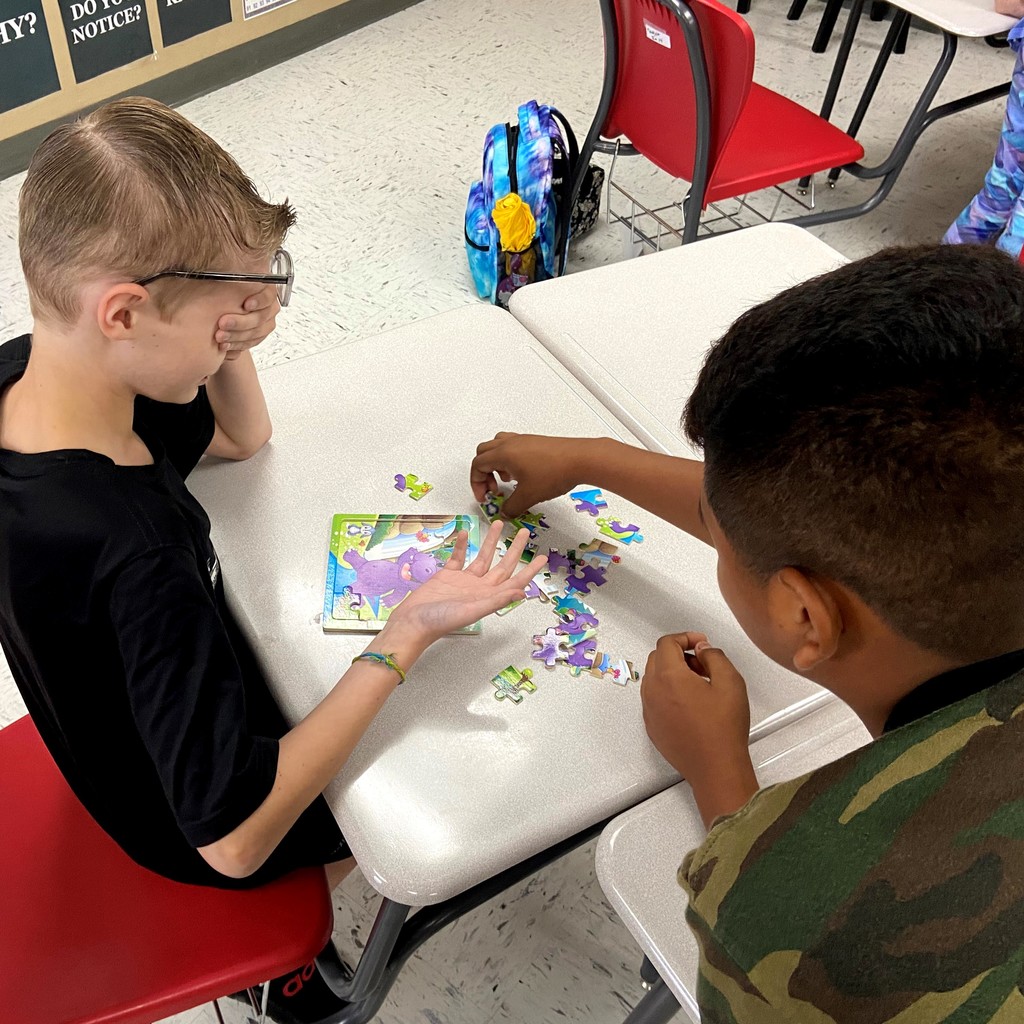 boys putting together puzzle