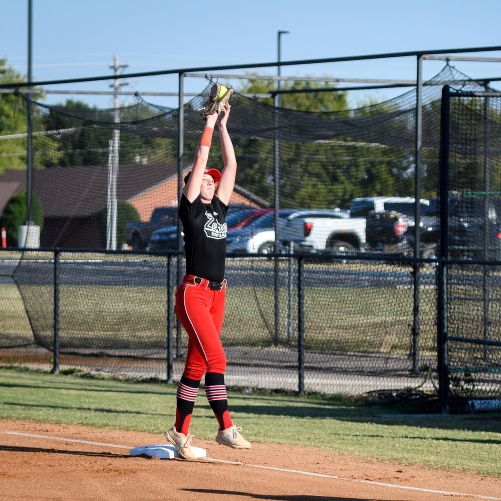 Softball girl catching at 1st base