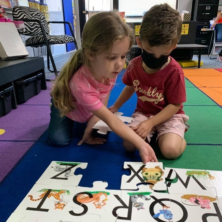 Two kids putting together a puzzle