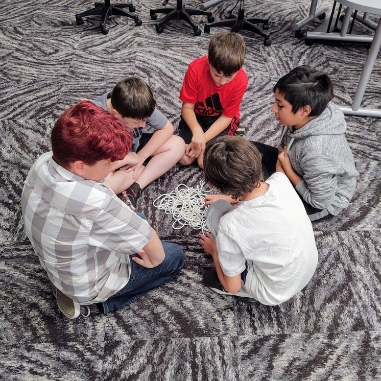 a group of boys looking at a pile of strings