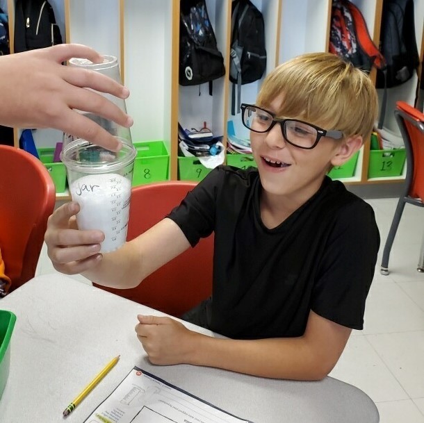 boy amazed at the chemical reaction in a beaker