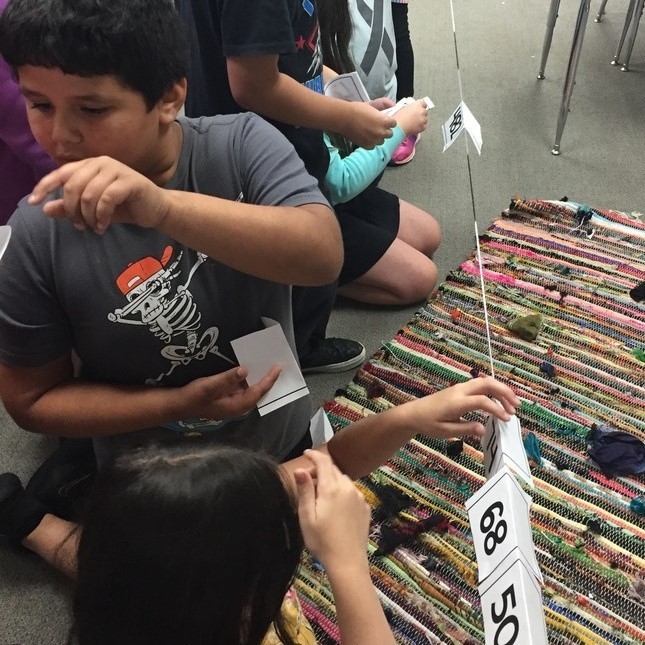student helping other student with the ordering of numbe ron the string