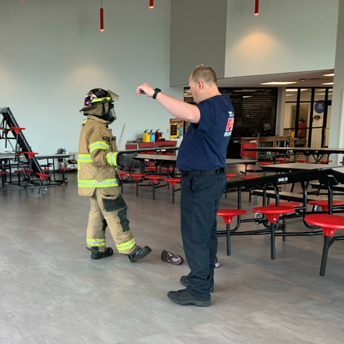 fireman with student in fire suit