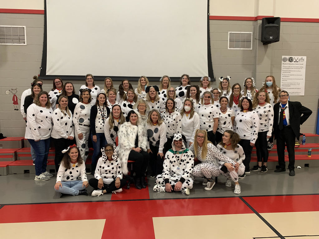 Principal dressed as Cruella & teachers as Dalmatians