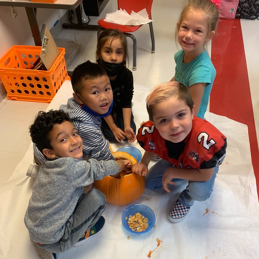 kids w/ hands in a pumpkin