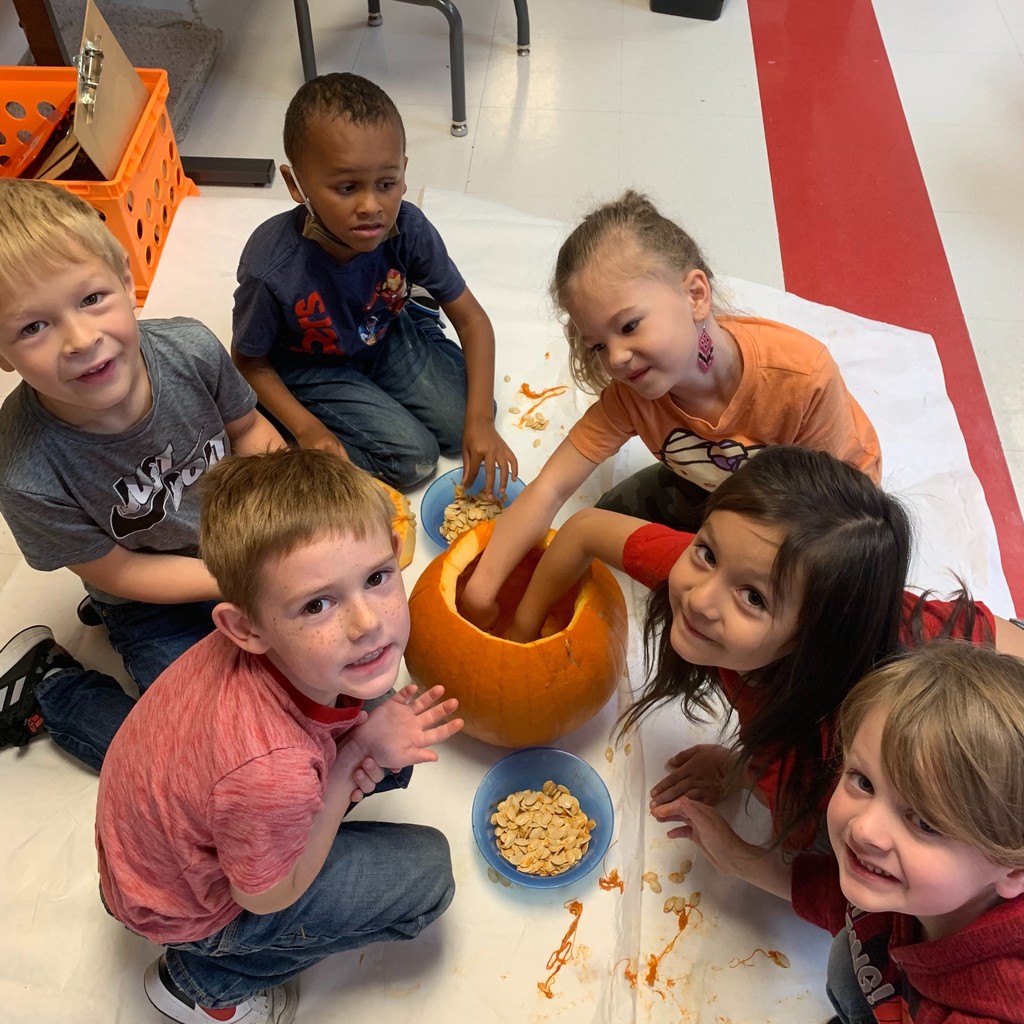 kids w/ hands in a pumpkin