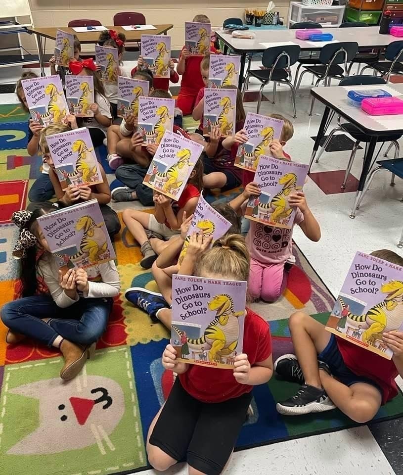 students holding books in front of their faces