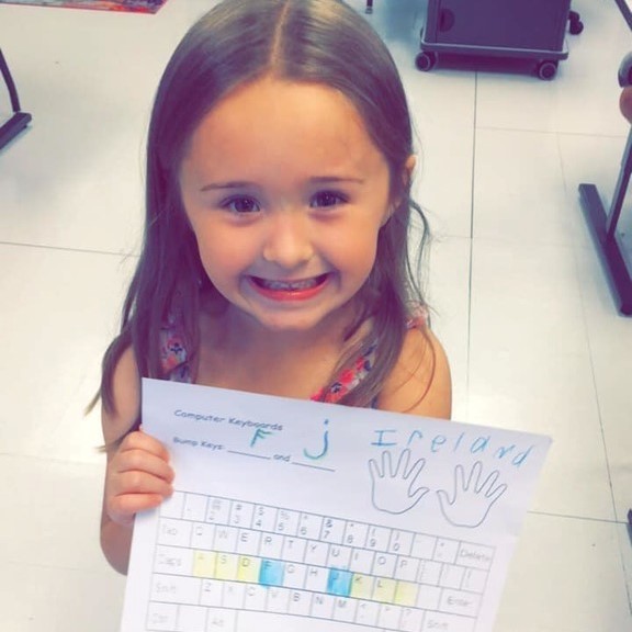 student with paper keyboard