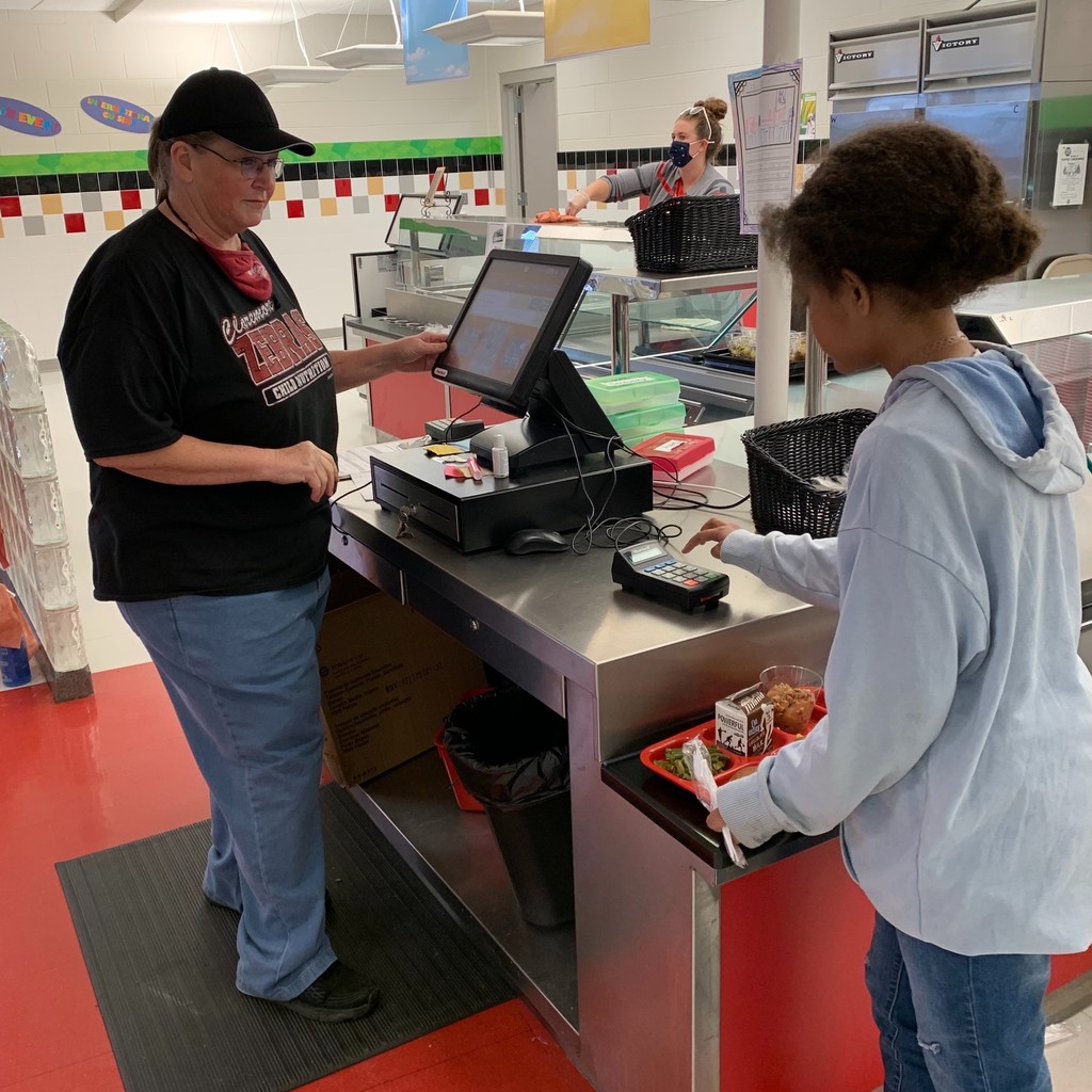 Thanksgiving meals cafeteria lady ringing up student meal