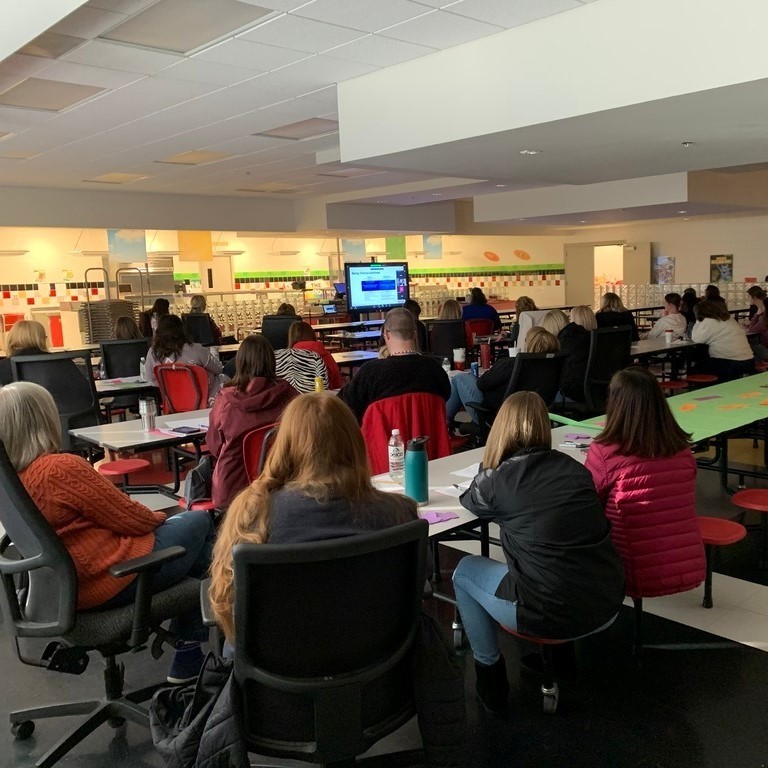 Teachers watching training on TV
