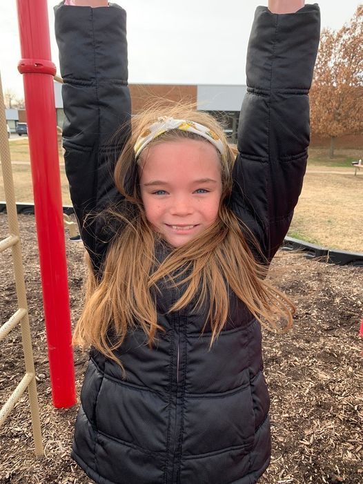 GIRL IN COAT ON MONKEY BARS