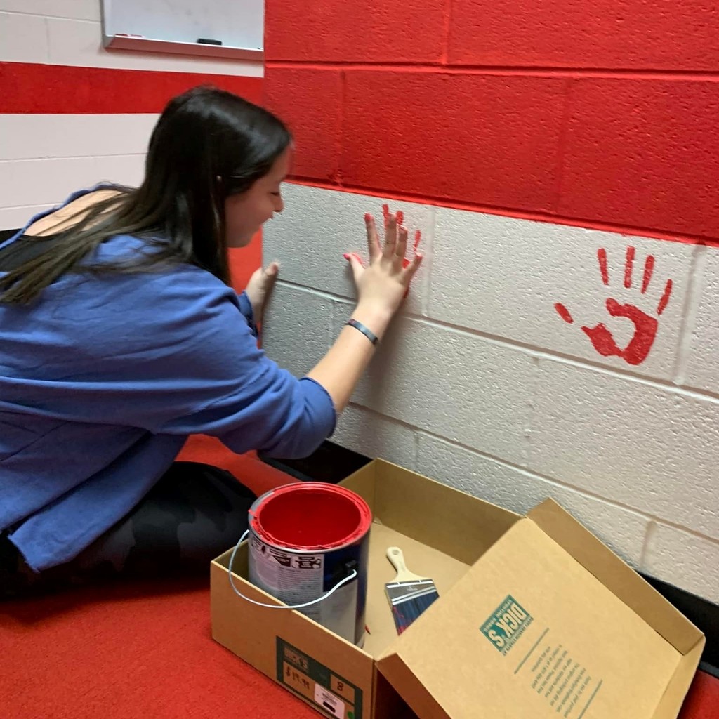 player paining her hand print on the wall 