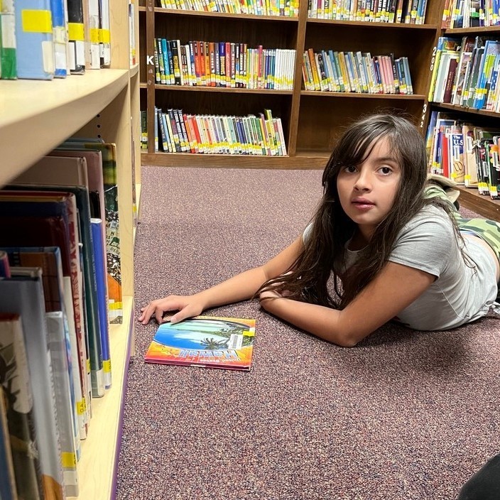 girl on floor reading a book