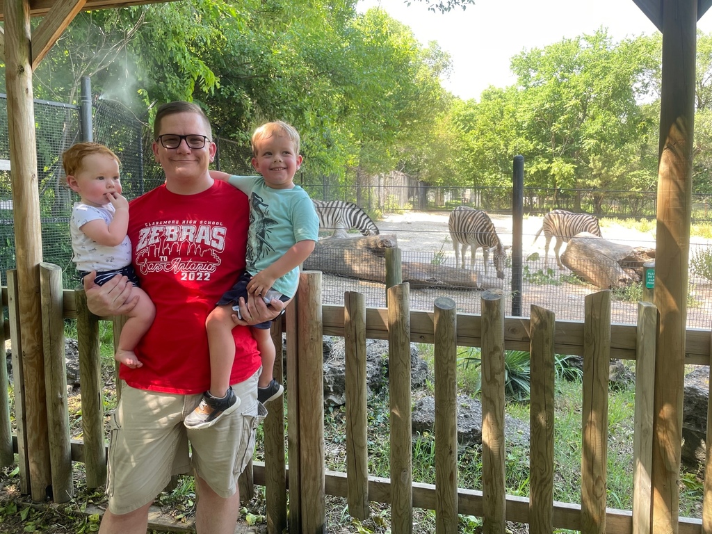 Dr. H with kids in front of zebra in the zoo