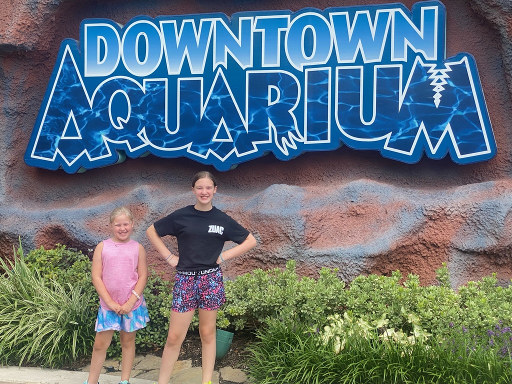 girds in front of downtown aquarium sign