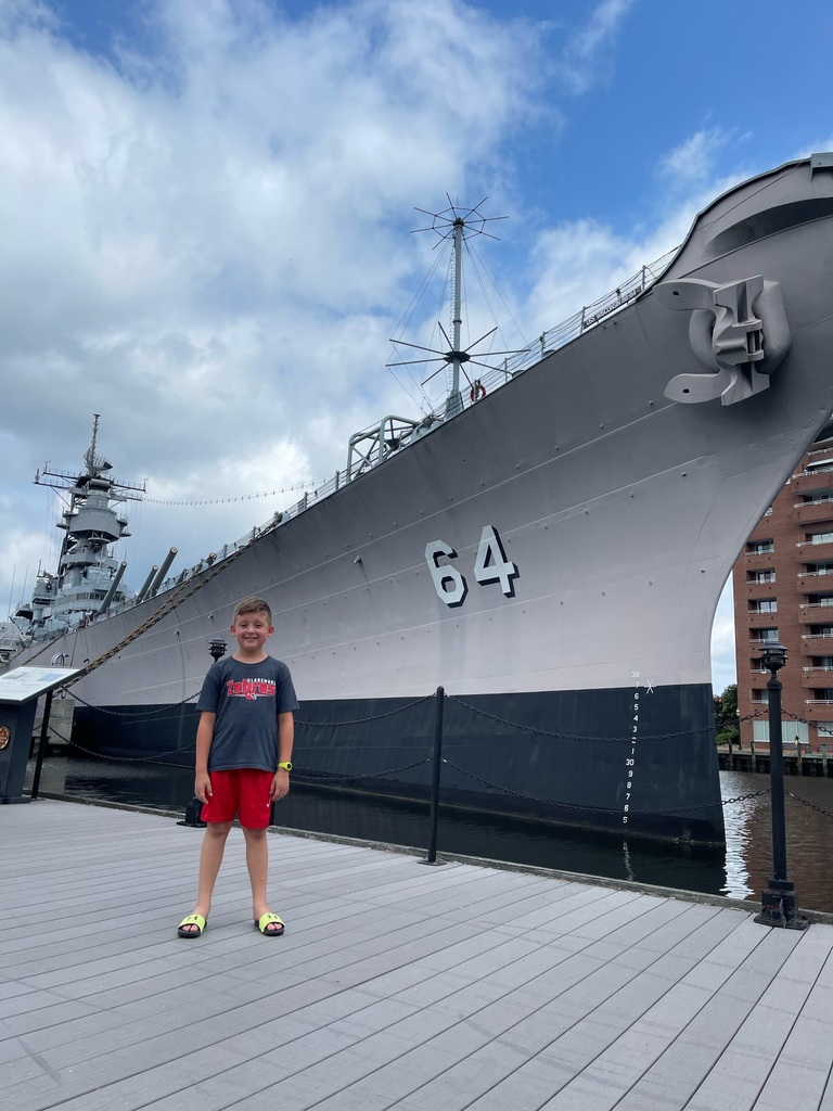 Asher in front of a navy ship