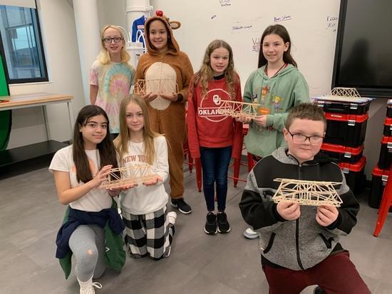 students holding bridges they built