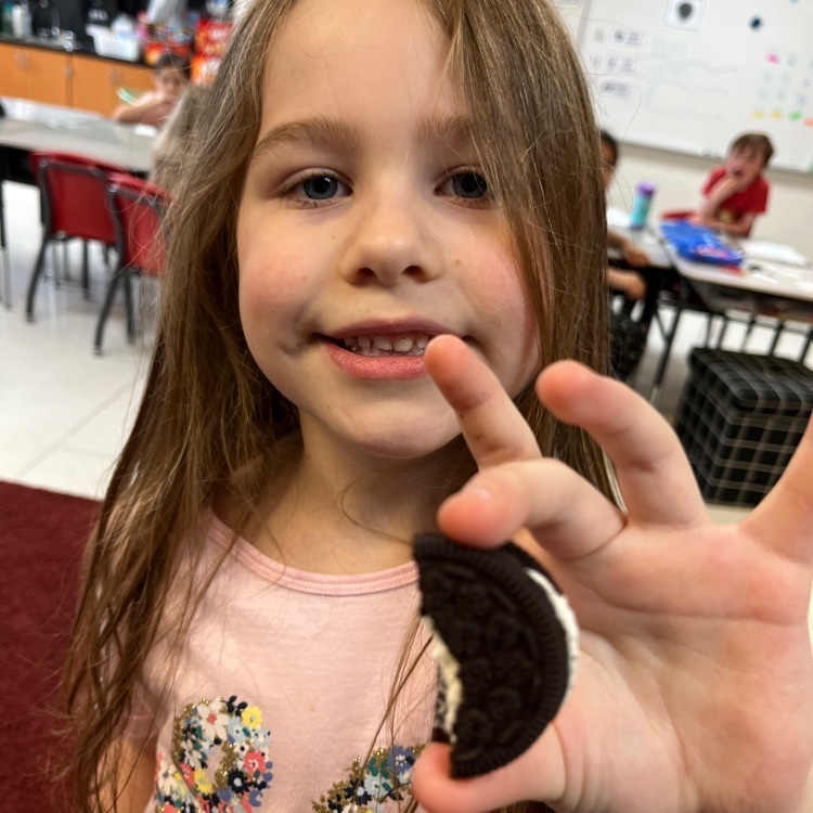 Student showing us an Oreo with a bite out of it