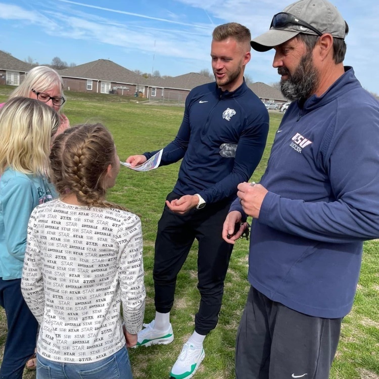 Soccer coaches, talking to elementary student