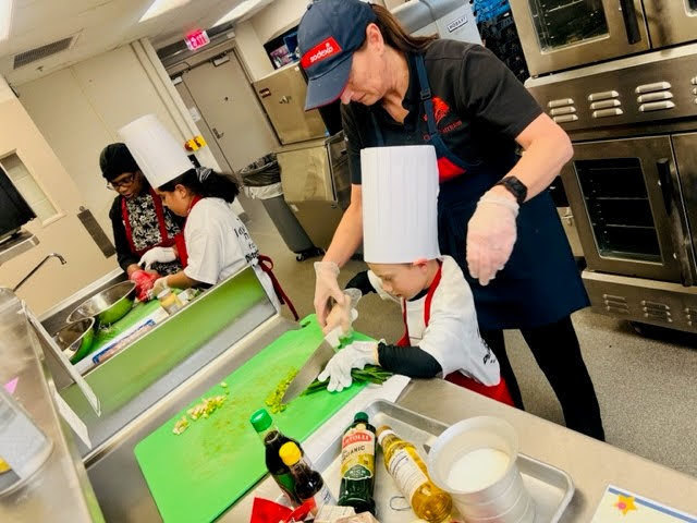 kitchen staff working with student
