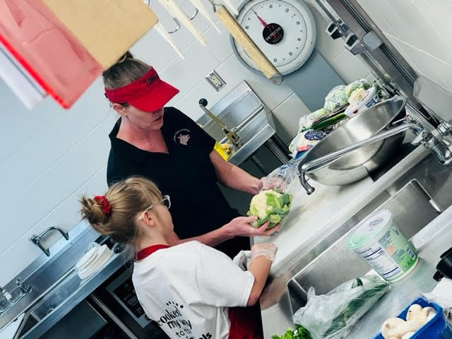kitchen staff working with student