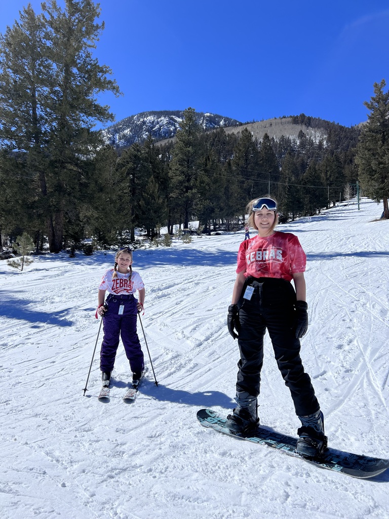 two girls snowboarding & skiing
