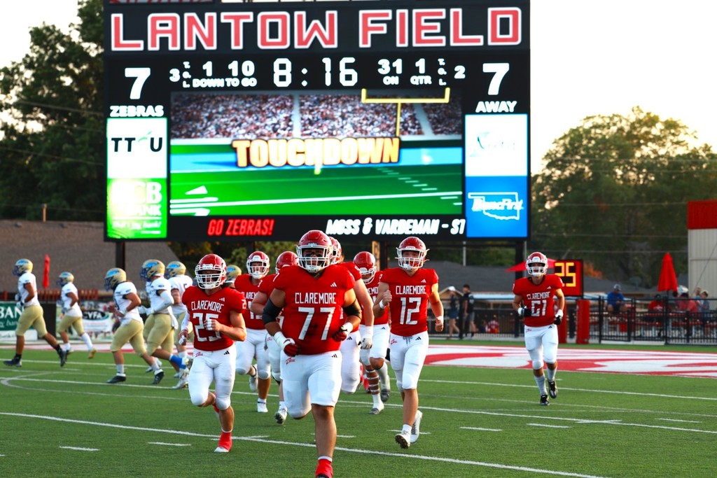 Claremore Football team running off the field after a touchdown