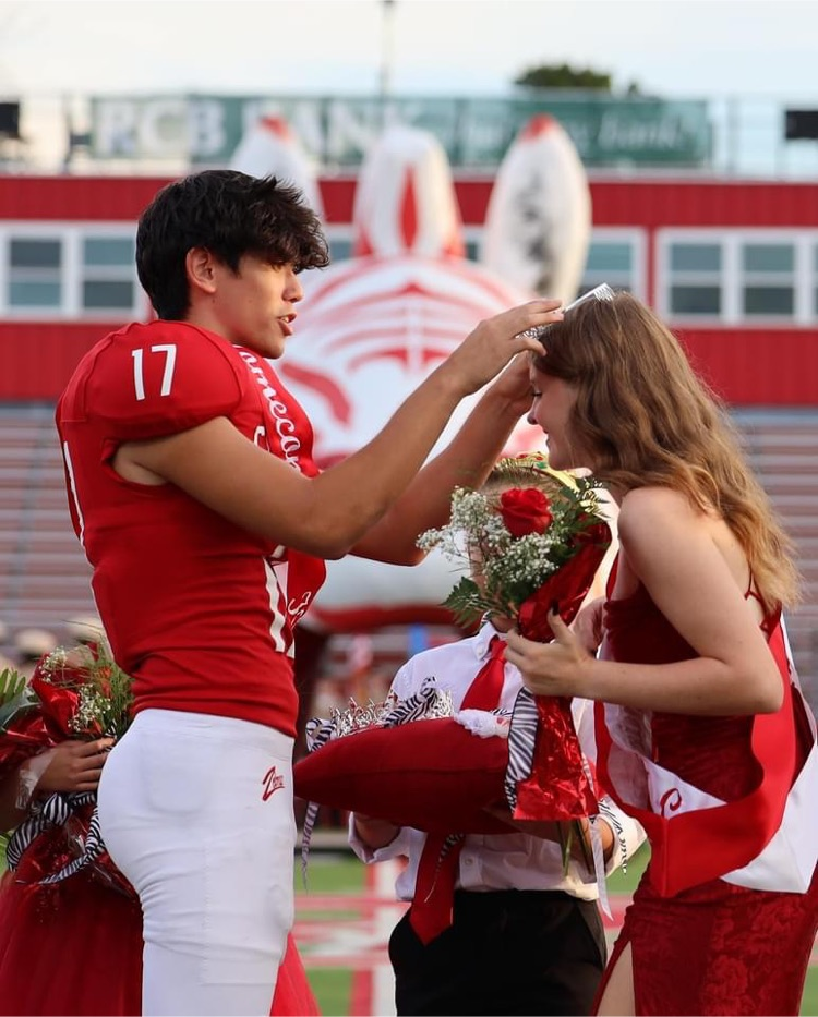football player putting a crown on Queen ‘s head