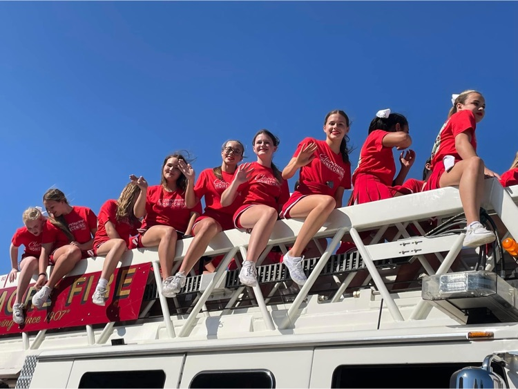 Cheerleaders on top of the fire truck