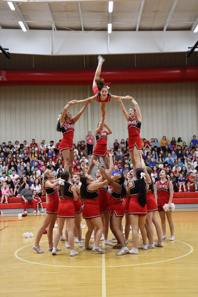 cheerleaders holding up a Fflyer in the air