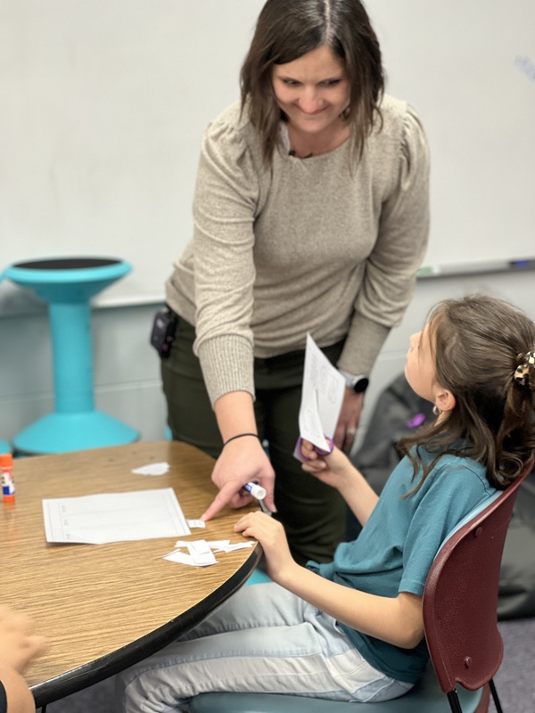 Lakey helping student at a table 